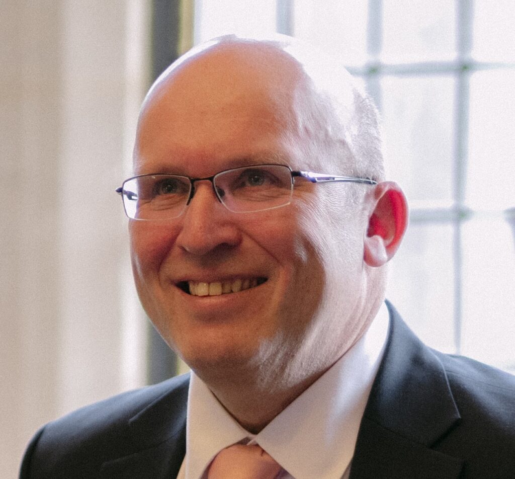 A headshot photo of Peter Burke smiling